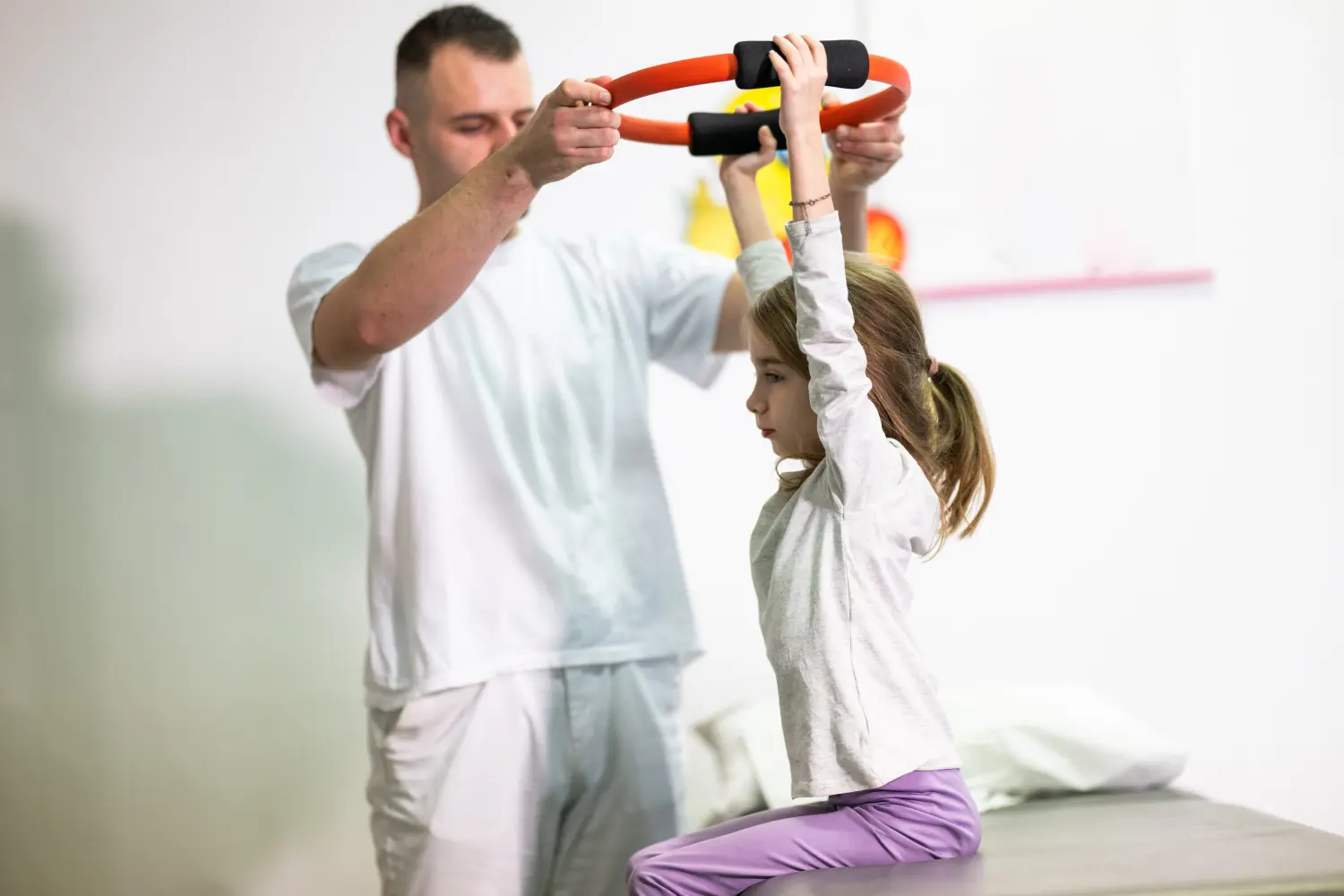 Praxis für Ergotherapie - medizinisch-therapeutische Behandlung - Kind macht Physiotherapie mit Ring